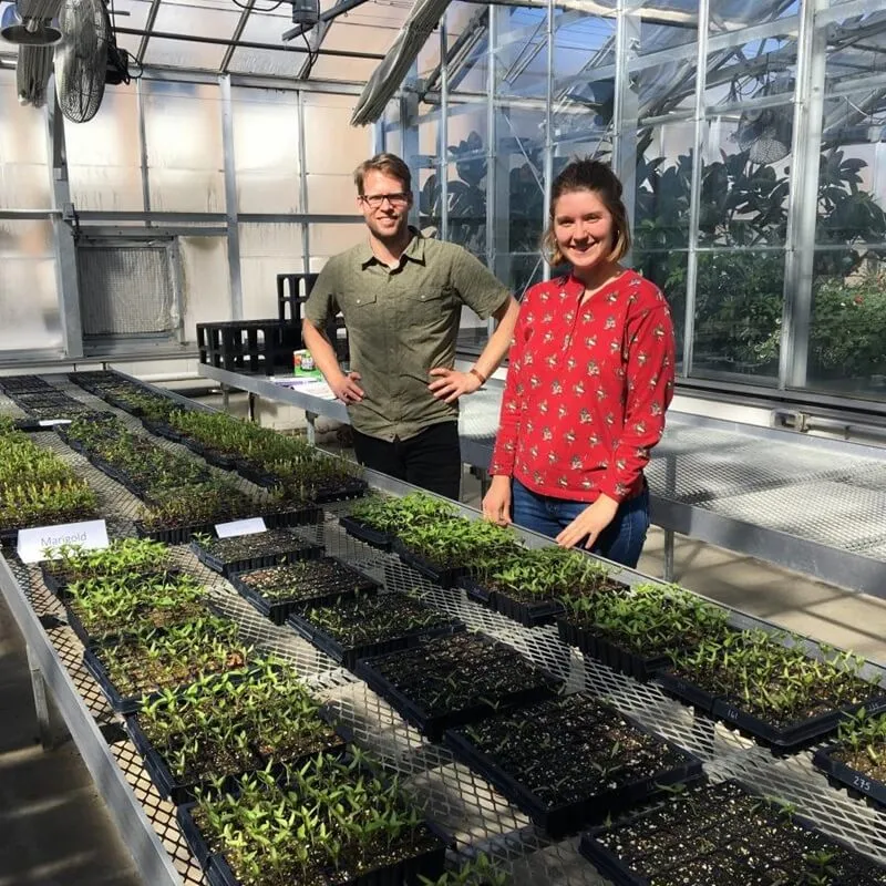 Eric Roy and Kate Porterfield standing in a greenhouse 