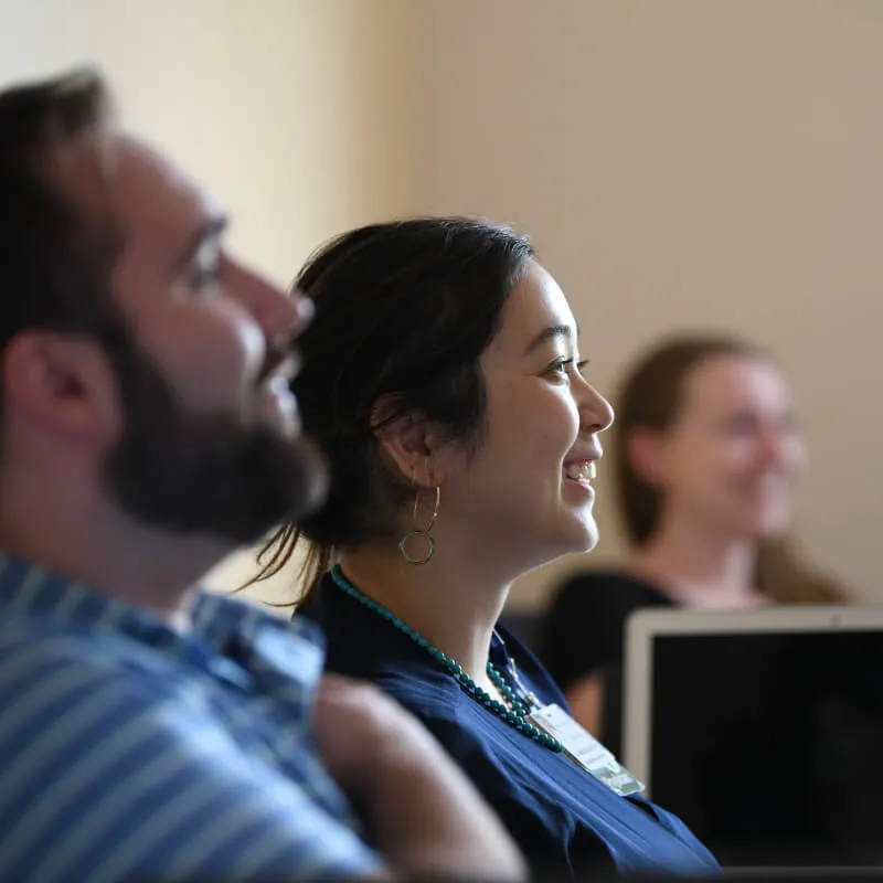 three individuals at a lecture laughing