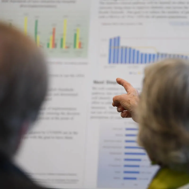 person pointing at a research poster