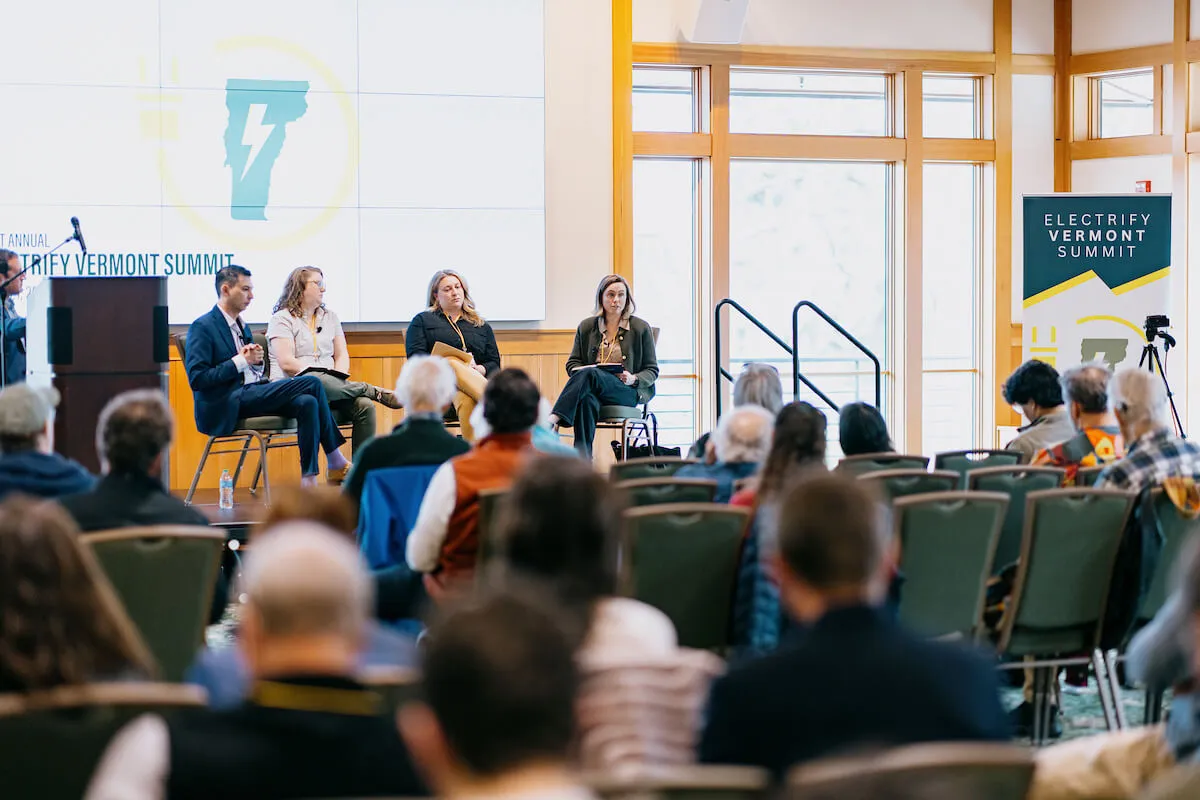 Panelists on stage discussing a topic at the Electrify Vermont Summit