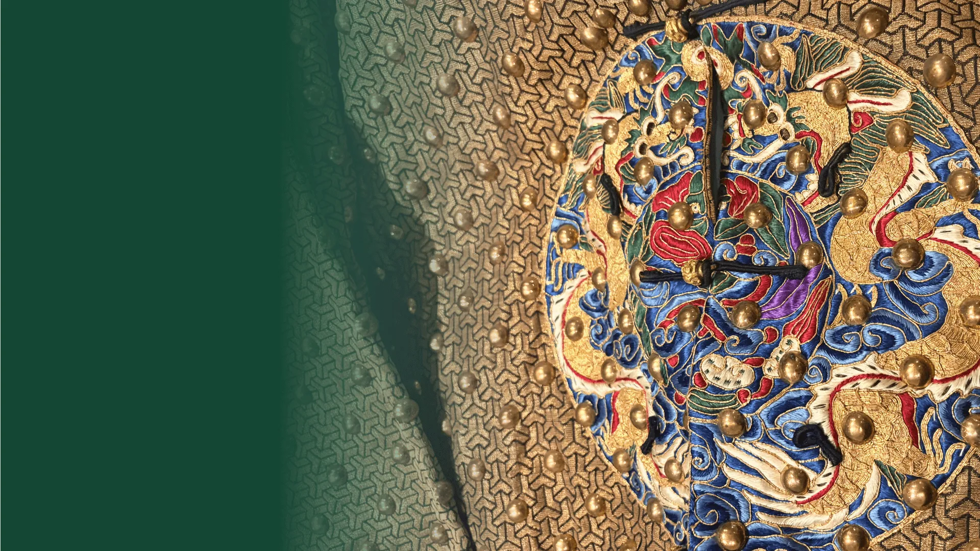 Close up of embroidered details in gold, red, and blue on a jacket.