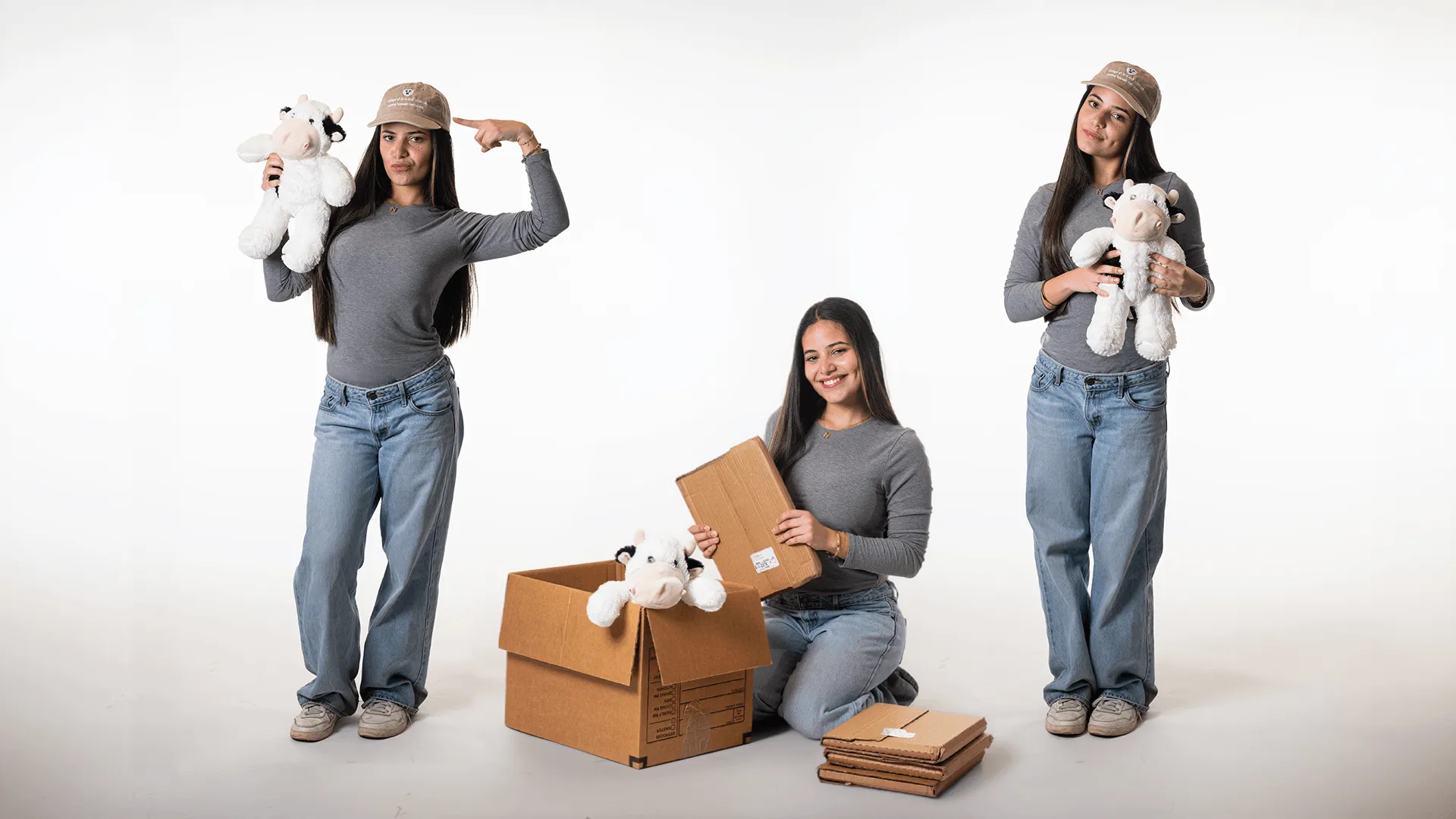 three individuals in different poses with a stuffed animal and boxes