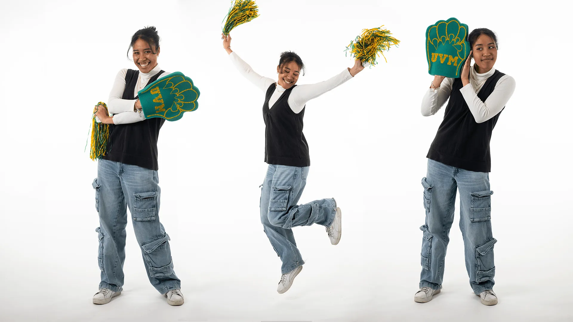 three individuals two with a green and gold foam paw and one with green and gold pom poms jumping in the air