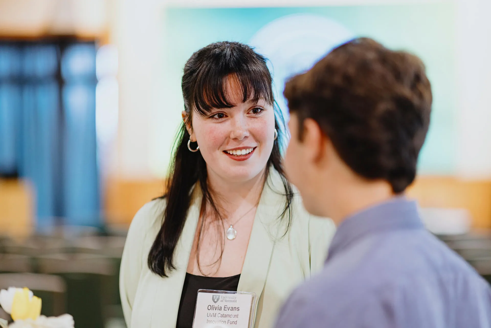 Two people talk in UVM's Alumni House Silver Pavilion