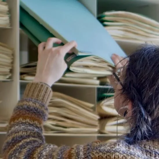 a young woman filing specimens in an herbarium cabinet