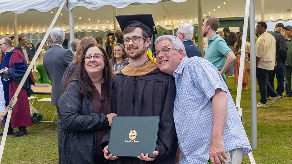 A Master of Accountancy Graduate poses with their parents