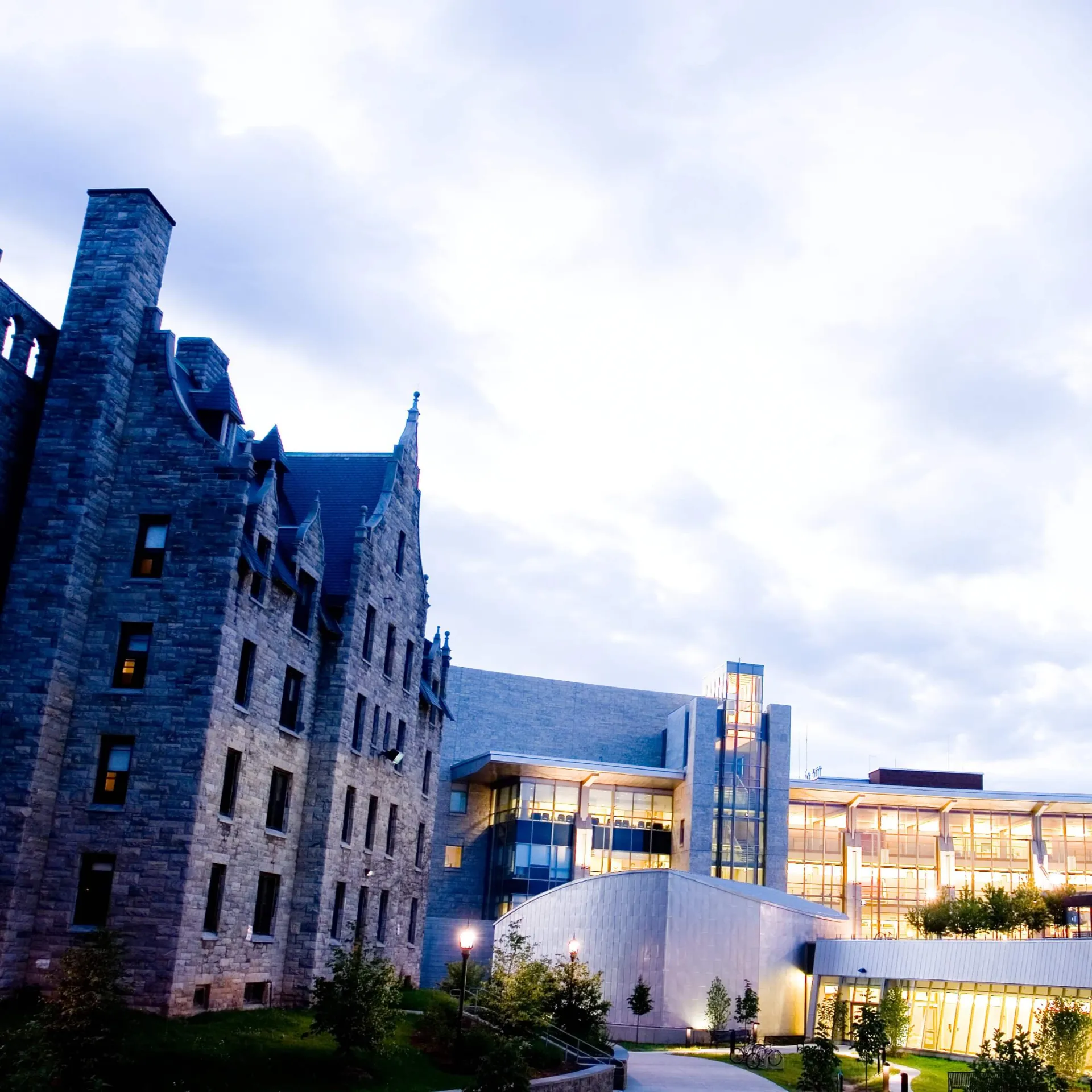Medical building at dusk/dawn, streets lights are on, building is glowing.