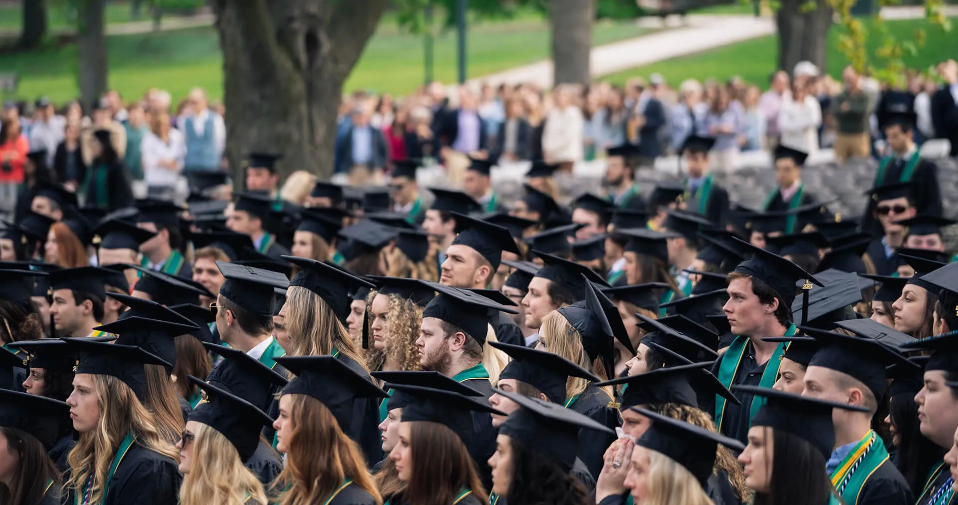 Graduates seated at an outdoor commencement ceremony.