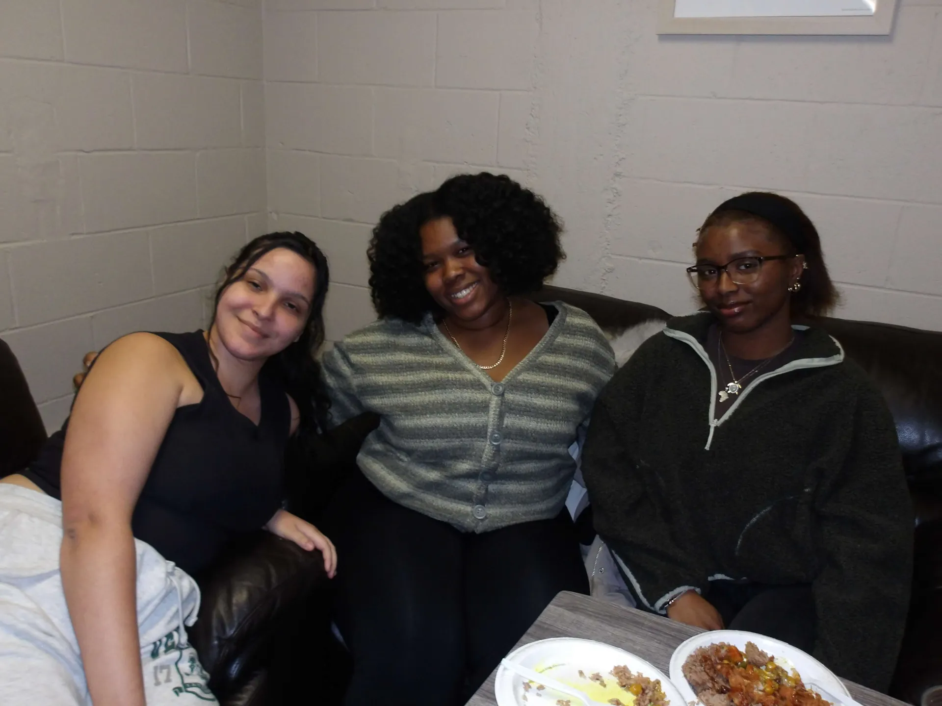 Students sitting in the Mosaic Main space and smiling 