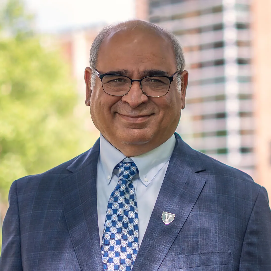 Dean Vikas Anand, Grossman School of Business, stands outside in front of Kalkin Hall