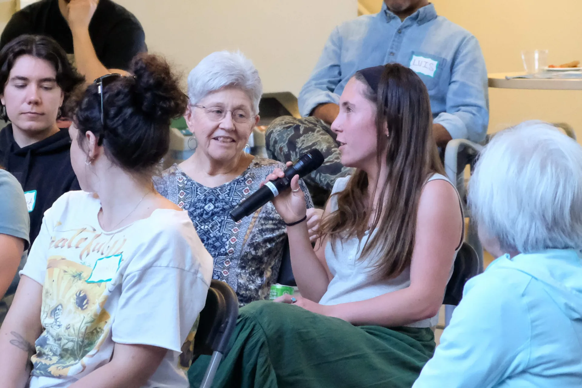 Student speaking into microphone in mixed age audience