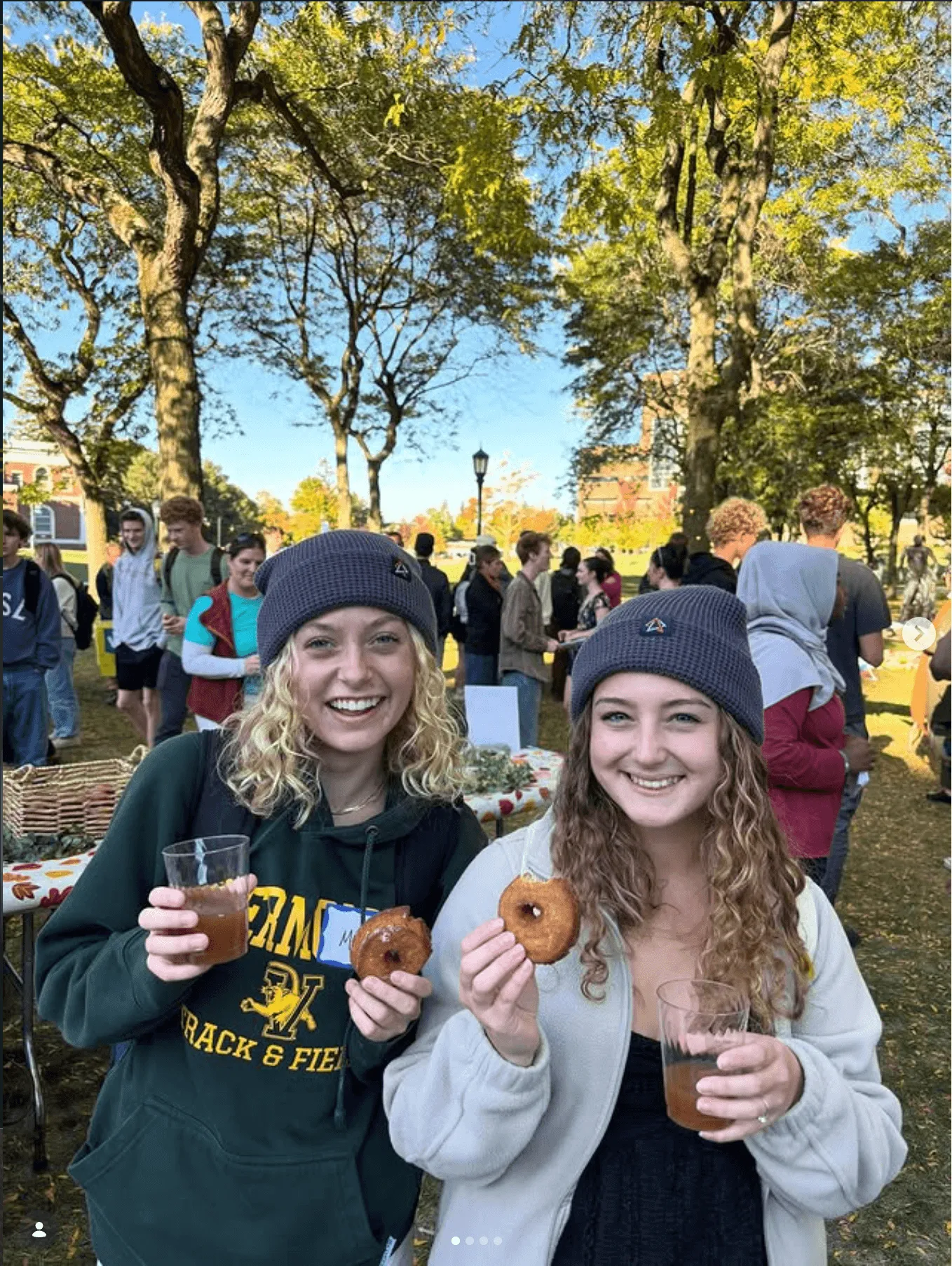 Two female students eating donuts in the fall