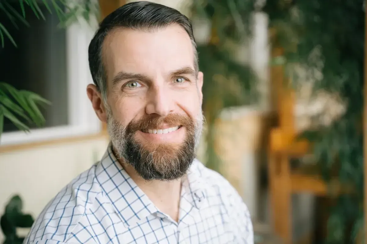 White man with beard smiling.