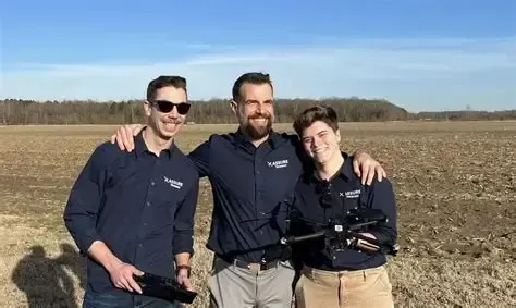 University of Vermont Drone Team standing in the middle of a field with a drone.