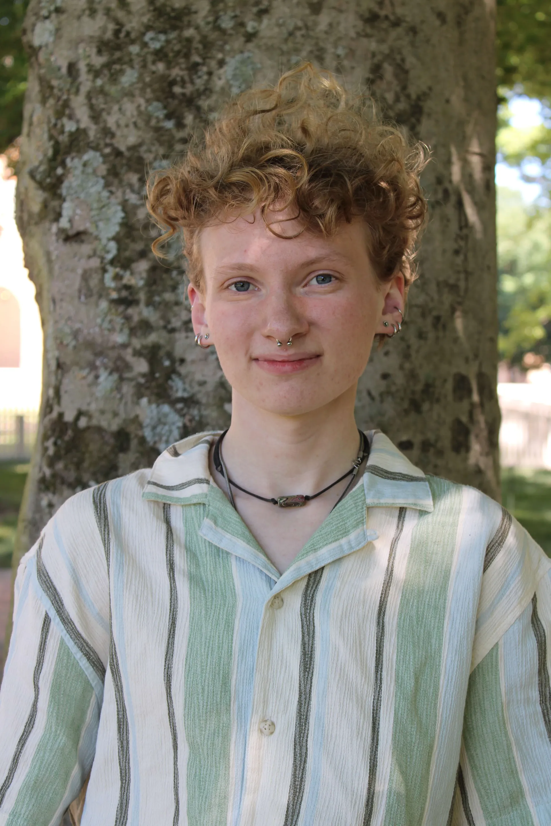 Student smiling in front of tree