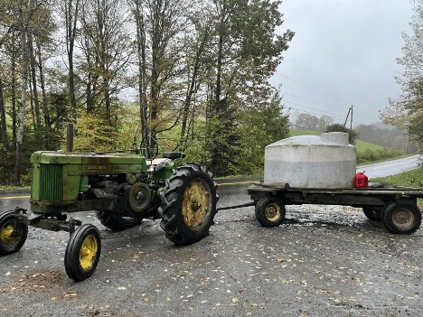 A water tank on top of a tractor trailer bed.