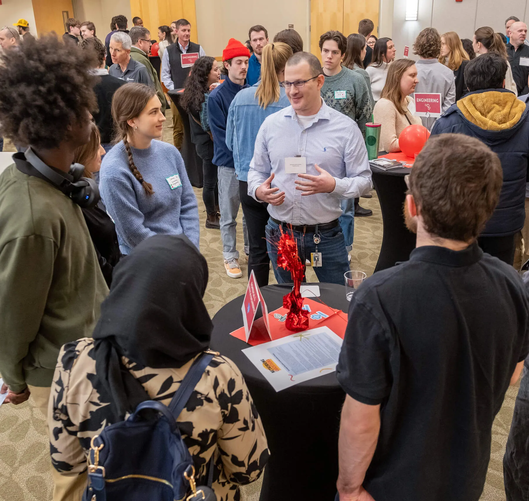 Students gather around a prospective employer's table during a STEM-focused career fair.
