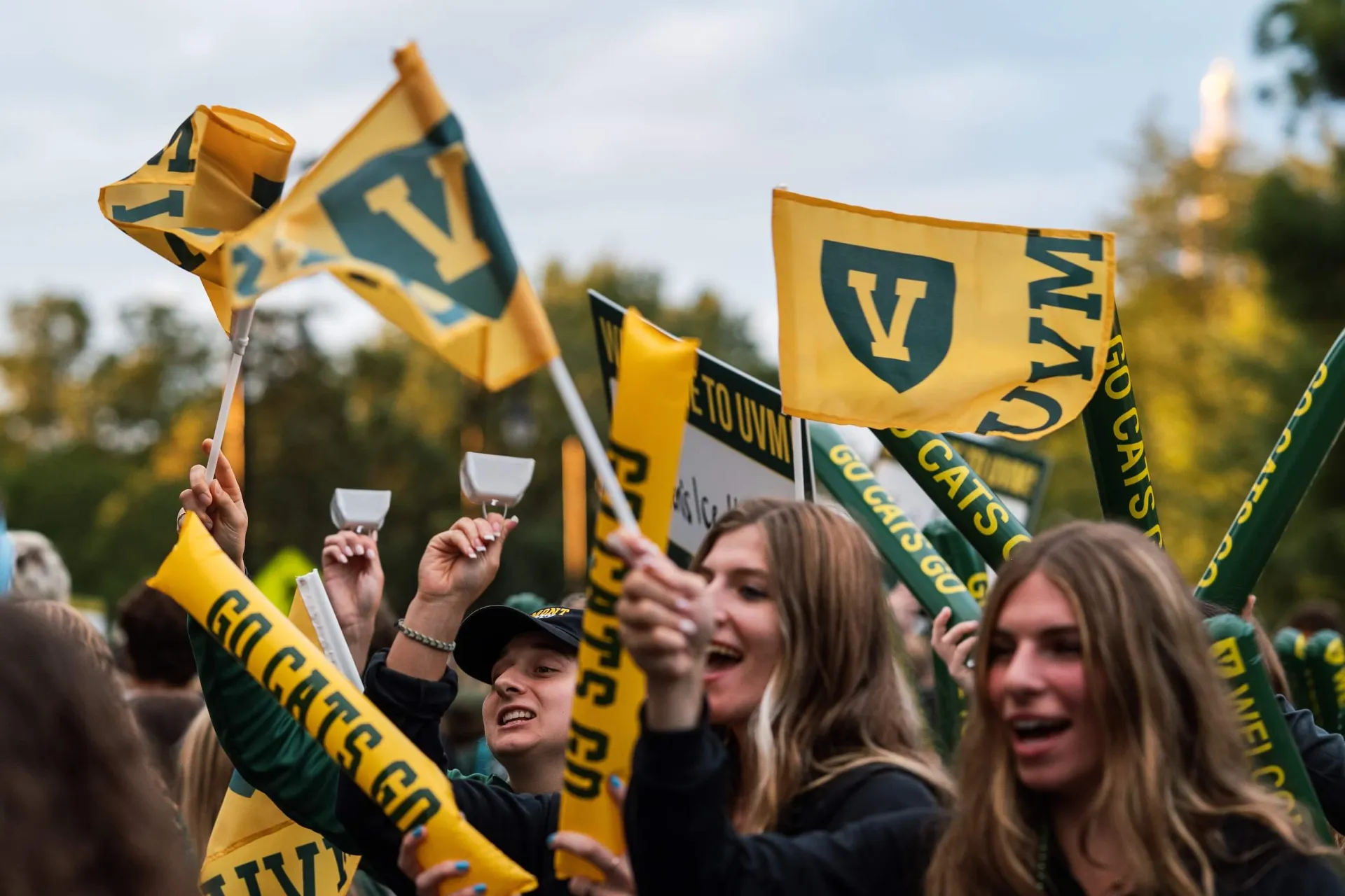 Students cheering and waving UVM flags.