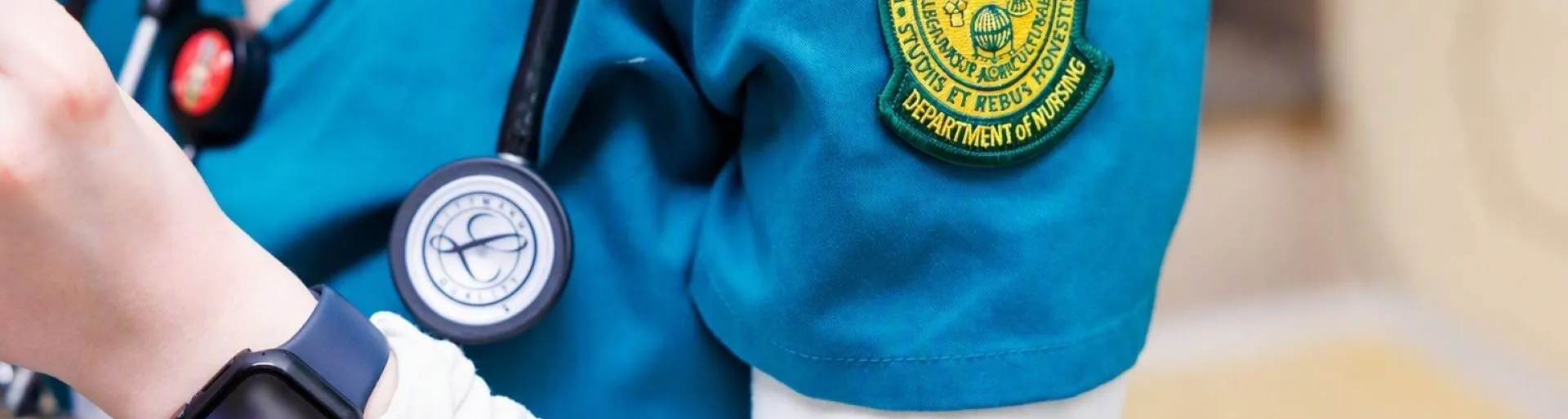 Close up of nursing scrubs with patch and stethoscope