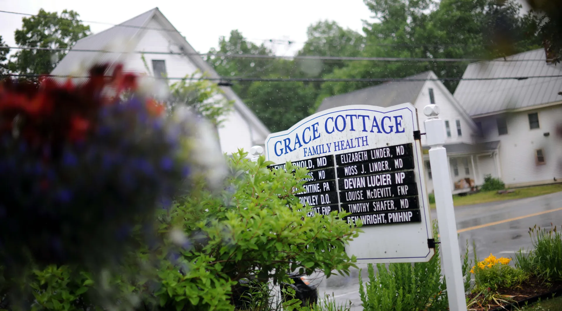 a sign for Grace Cottage Family Health listing the practitioners' names