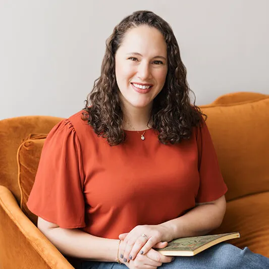 Person smiling while seated on a couch.