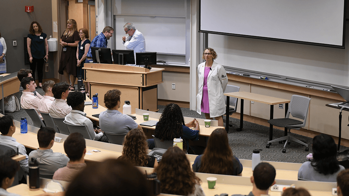 Doctor standing in a room full of people