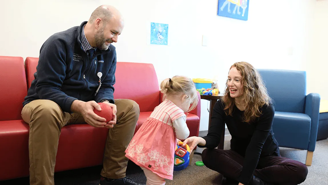 Two doctors playing with a young child