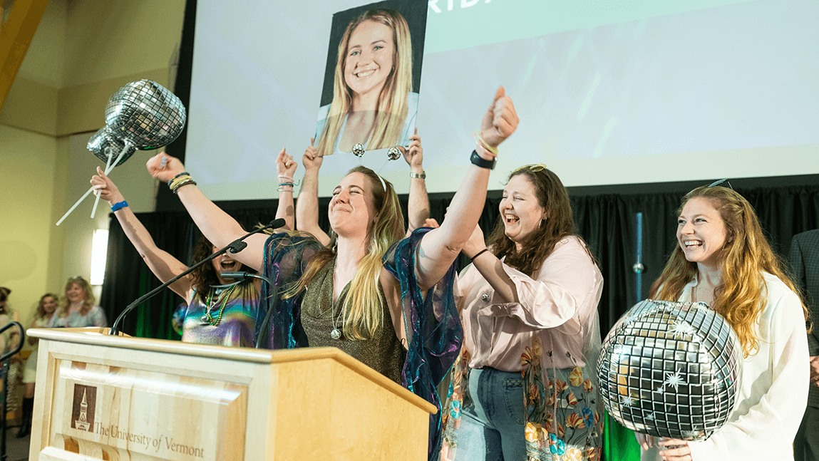 People standing with their arms up in front of podium