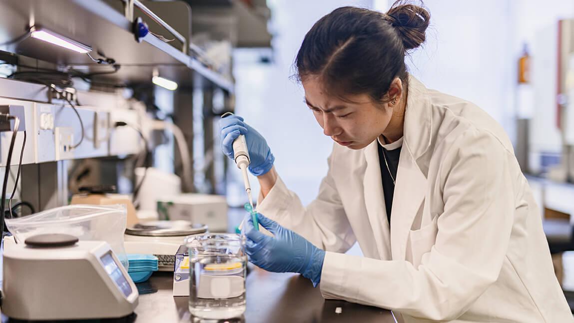 A student intern working at a lab bench.