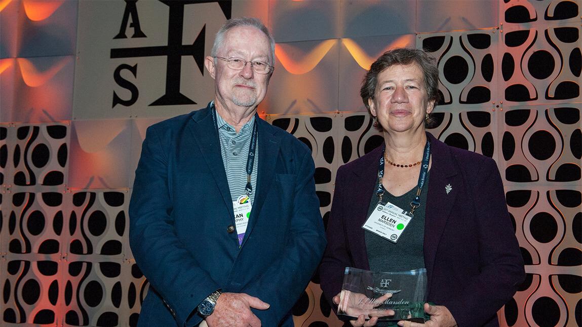 Ellen Marsden holding award stands next to Brian Murphy