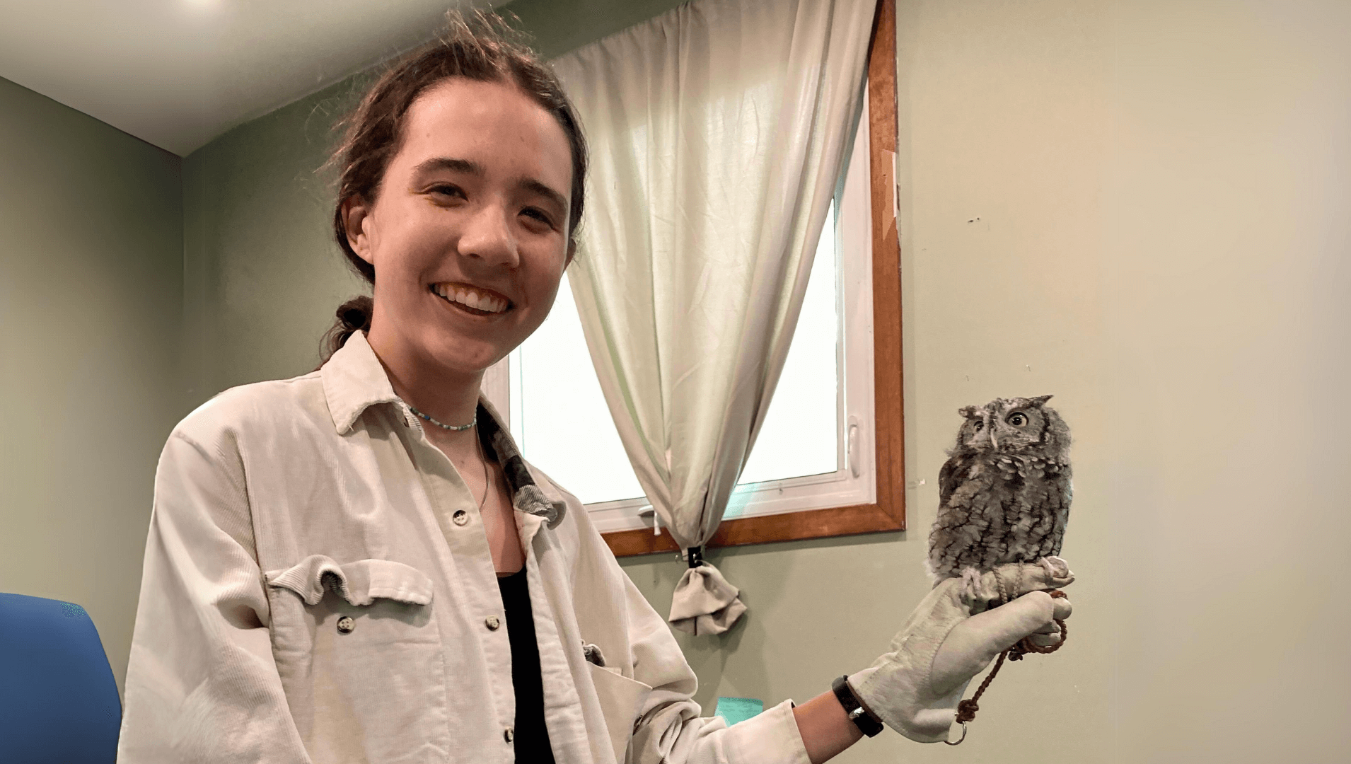 Rubenstein student Ann Haas ('26) hold up an Eastern Screech Owl