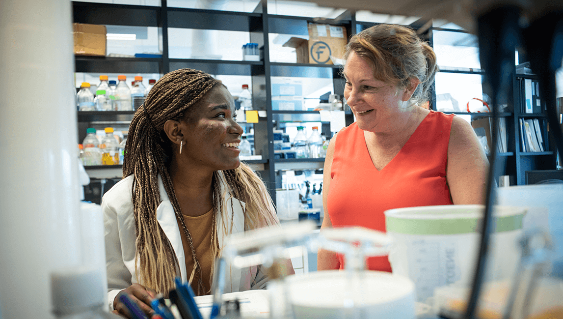 Dorcas Lohese in laboratory environment with a student