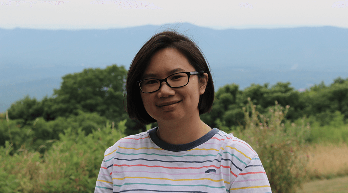 Jennifer Lai in foreground with forest and mountains in background