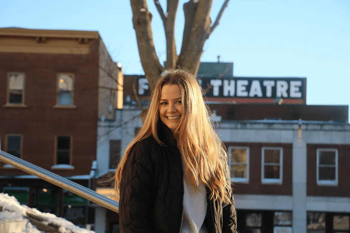 Sarah Blow in front of row of buildings