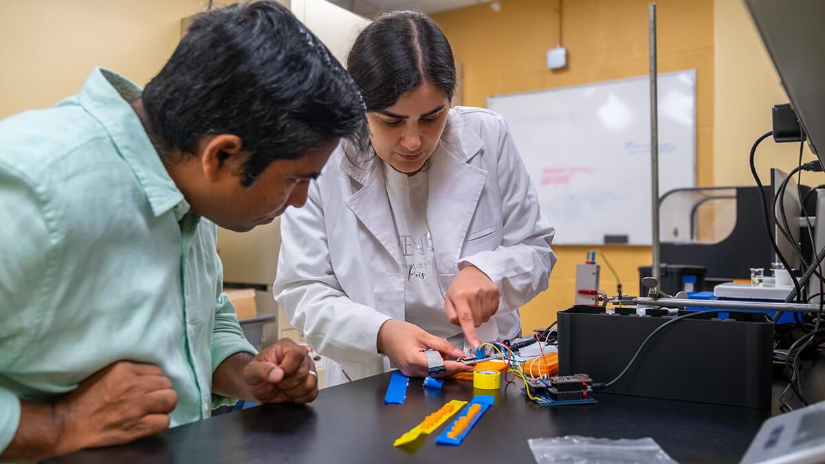 Dr. Appala Raju Badireddy and Post-Doctoral Research Associate Monireh Dehabadi examine the electronics for a prototype of an advanced sensor box