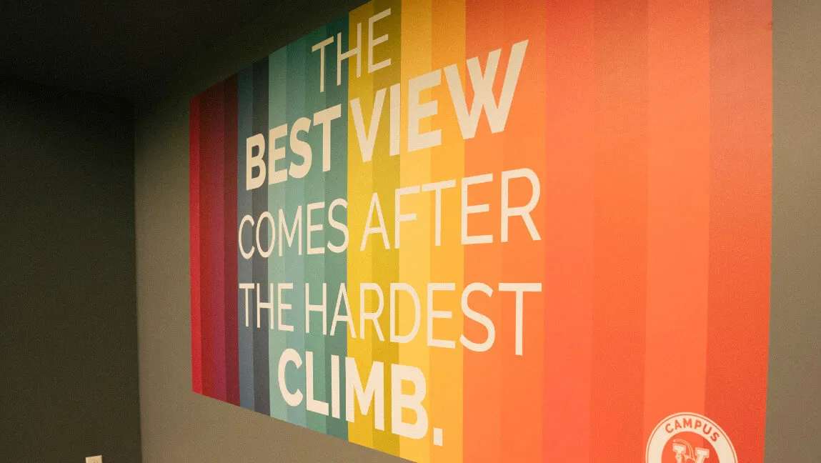 Rainbow colored sign reading "The Best View Comes After the Hardest Climb"