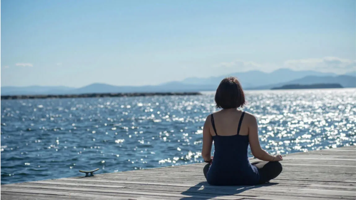 Person sitting on dock with view of lake