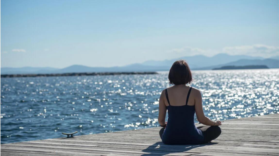 Person sitting on dock with view of lake