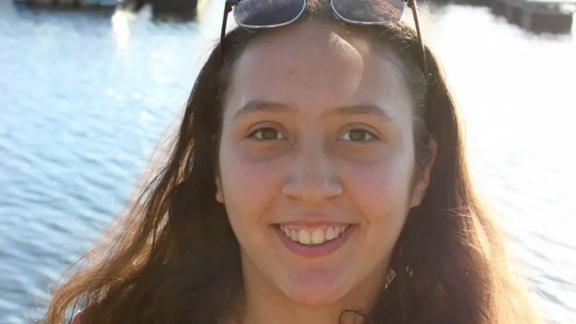 Oumaima Sriji smiles with water and boat dock in background