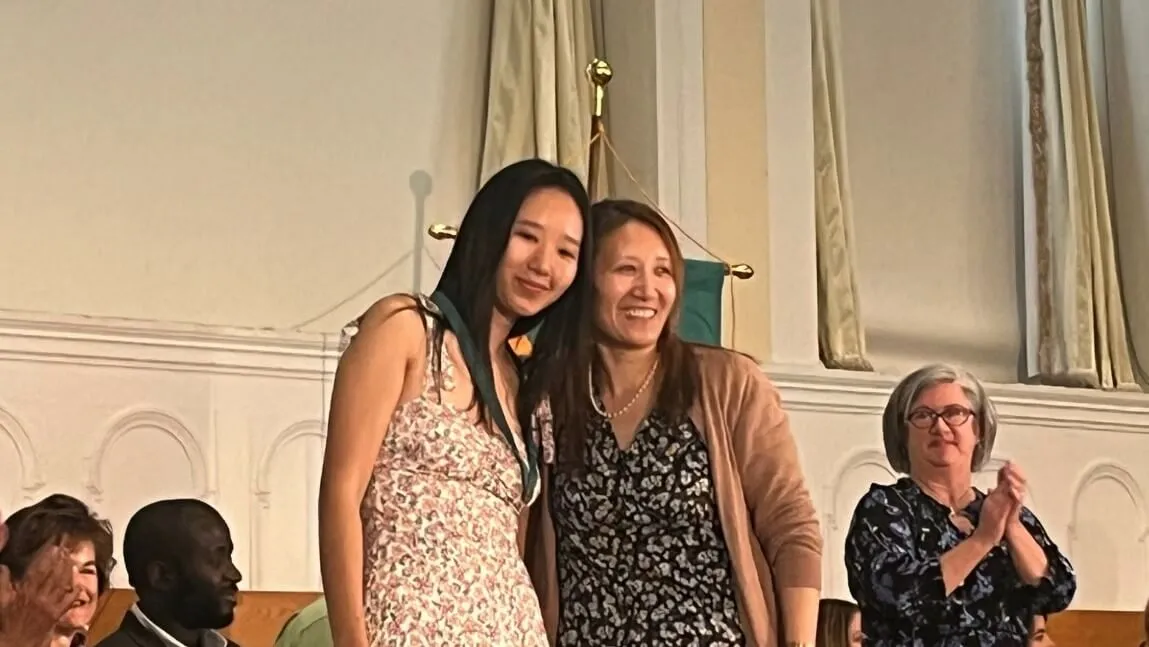Nursing graduate Jaza Amchok '23 (left) poses with her mother after receiving her nursing pin.