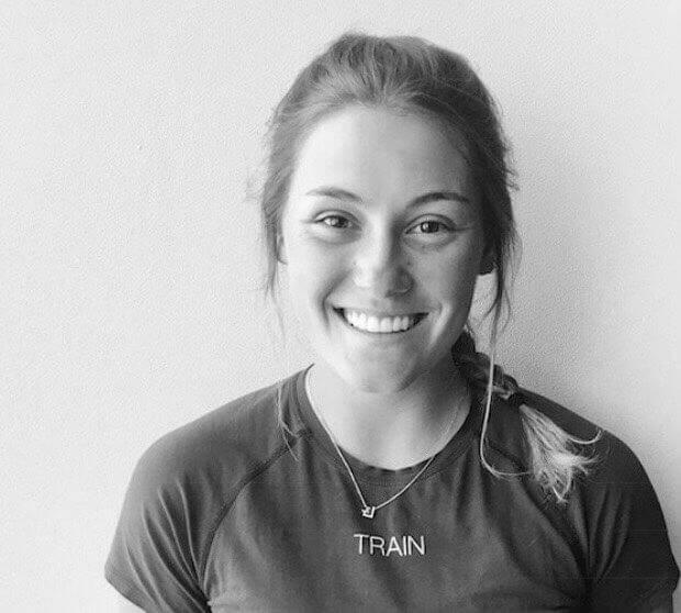 Black and white headshot of Katherine with a big grin