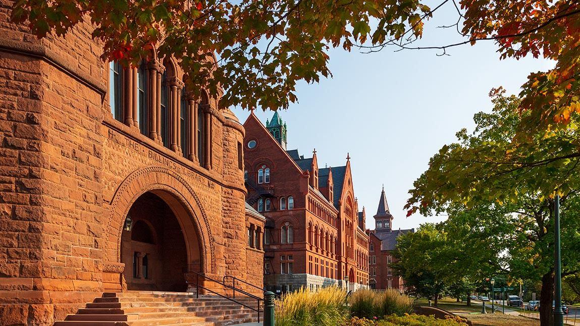 sun shining on brick buildings on the UVM green