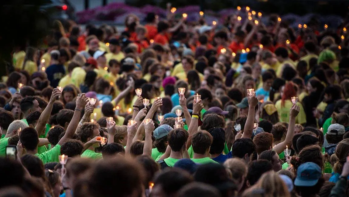 students holding lit candles at convocation ceremony