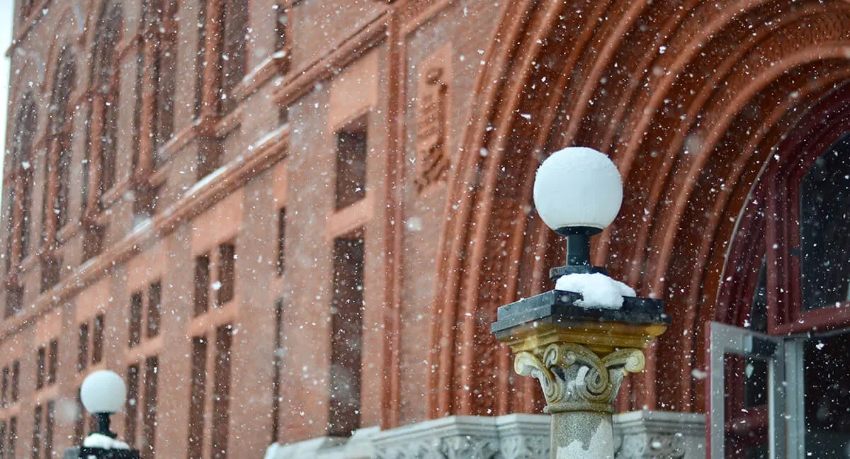 snowing in front of campus building