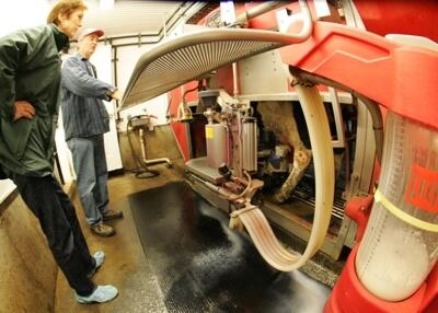 Farmer Clark Hinsdale III and UVM College of Agriculture and Life Sciences associate dean Josie Davis inspect robotic milkers.