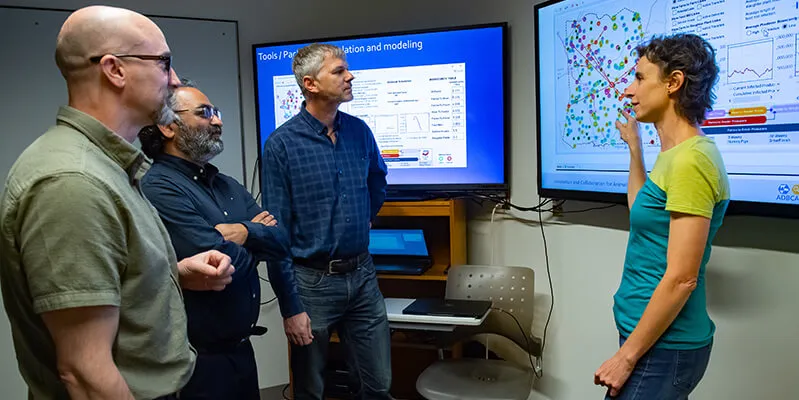 people standing in front of tv monitor