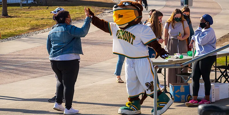 student high fives with kitty catamount