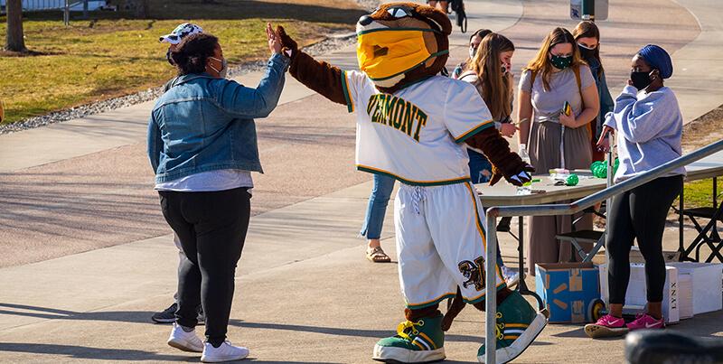 student high fives with kitty catamount