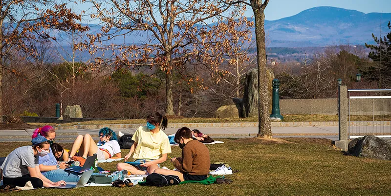 group of students wearing masks outside with MT Mansfield in background