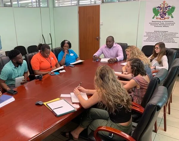 Students meeting with St. Lucian representatives at a table